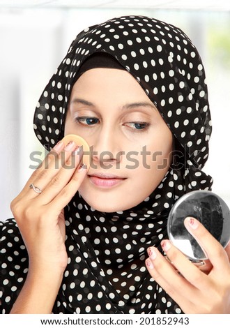 beautiful young adult woman with cotton pad. applying face powder