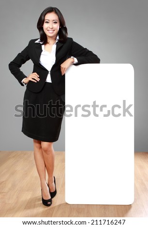 full body portrait of beautiful businesswoman holding blank billboard on grey background