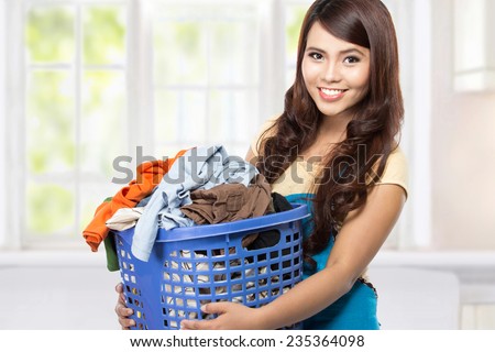 woman doing a housework holding laundry