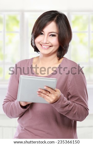 portrait casual middle aged  Woman holding and touch tablet computer