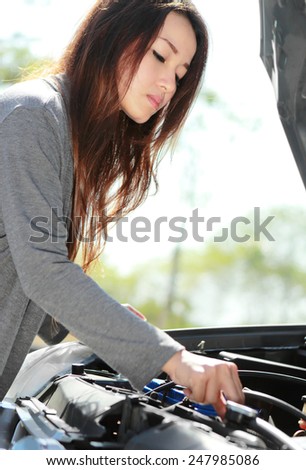 portrait of young woman try to fix engine problem of her car