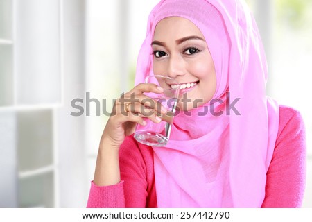 portrait of beautiful young muslim woman drink a glass of water