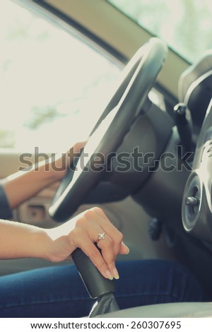 portrait of woman driving and shifting car transmission with both hands