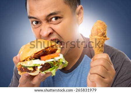 A portrait of a young man bite his big burger deliciously