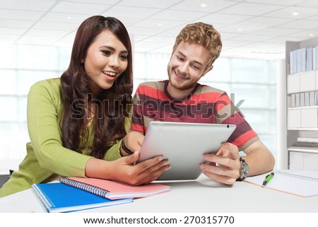 A portrait of two students checking their social media activity while studying
