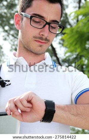close up portrait of college student looking at the time on his watch