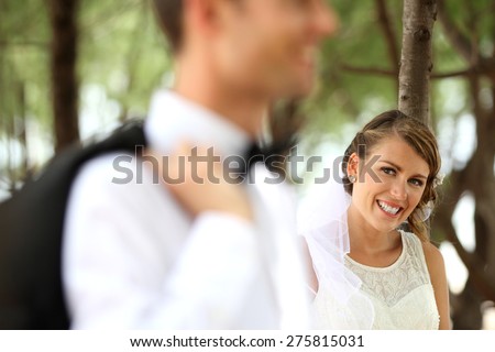 portrait of bride smiling and looking at her groom. focus on bride