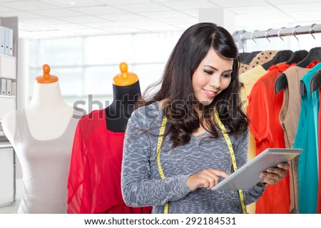 A portrait of a happy young fashion designer working on a design or draft