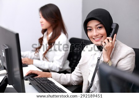 portrait of beautiful businesswoman smiling while answering the telephone at office
