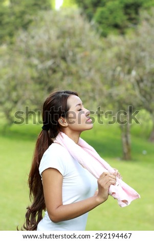portrait of sporty woman take a deep breath at the park with fresh air