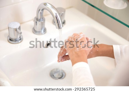 A portrait of a pair of hands, washing with soap under running water, woman hands