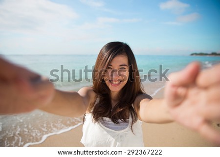 A portrait of a Happy young Asian woman take photos of her self, smile to camera