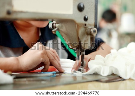 portrait of worker using industrial sewing machine at garment