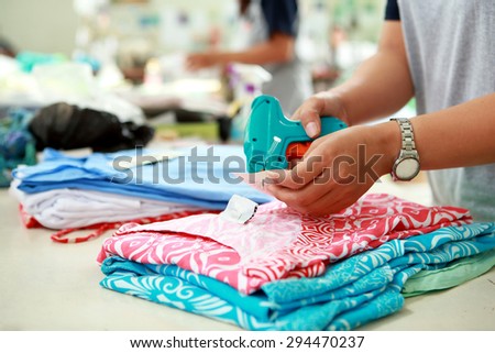 close up portrait of labeling process for cloting product at textile factory