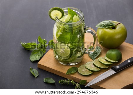 portrait of Summer fresh fruit drink. fruit Flavored water mix with lime, apple and basil leaves
