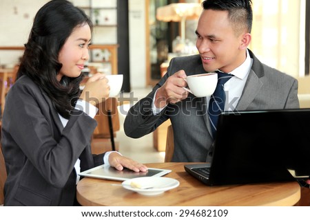 portrait of two young business people meeting during coffee break at coffee shop