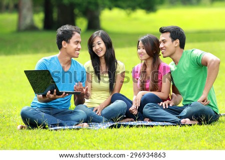 portrait of Group of students studying in the park using laptop computer