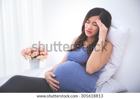 pregnant woman having a headache and morning sickness