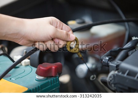 A portrait of a hand Checking for engine oil on a car, machine related