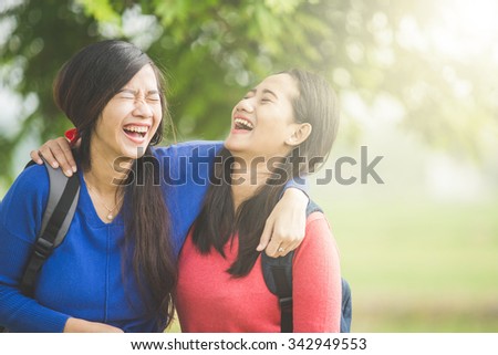 A portrait of happy two young Asian students laugh, joking around together