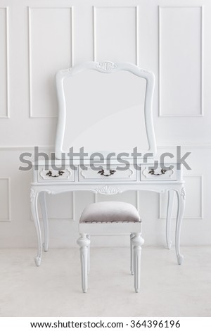 portrait of vintage vanity table set with stool and mirror on white patterned wall