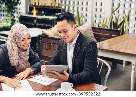 two asian business team meeting at a cafe using tablet pc