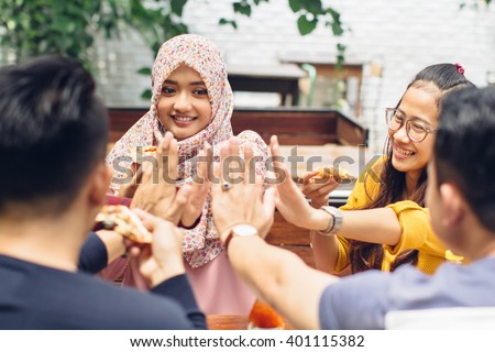 portrait of asian friend giving high five at cafe while having a lunch