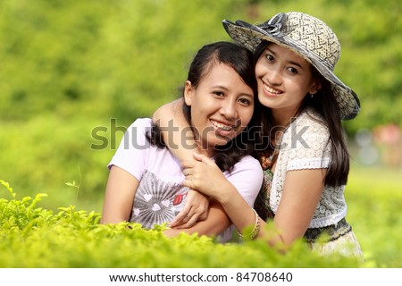 happy girl friends smiling together in green nature