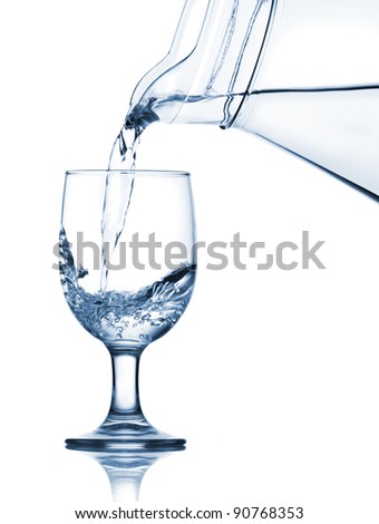 Pouring water into the glass from jug. Isolated over white background