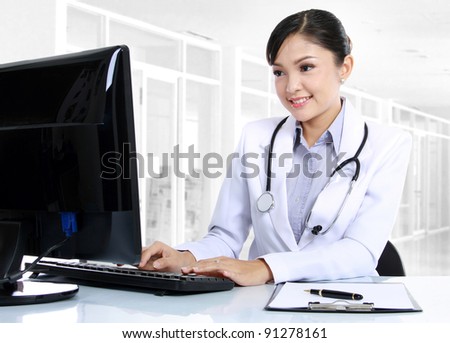 front view of smiling woman doctor working on computer