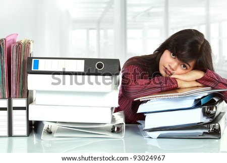 young business woman with many paper work stressed at work