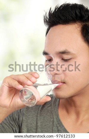 close up portrait of young man drinking water