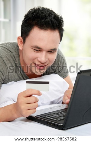 man purchasing product online, using credit card to pay
