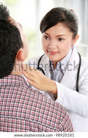 Closeup of woman doctor checking young man neck