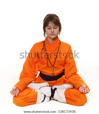 the girl in the orange suit is sitting in meditation on a white