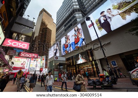 HONG KONG - MARCH 24 2015 : People walking across Hennessy Road, Causeway Bay in front of a big department store Sogo at Day.