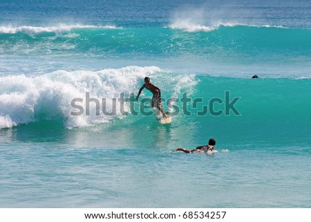 BALI, INDONESIA - JULY 27: Unidentified young man surfs the waves on July 27, 2010. Dreamland beach, Bali, Indonesia. The Dreamland is one of the most popular surfing areas of Bali.
