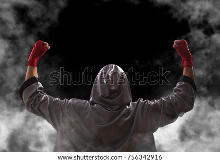 Female boxer with red boxing wraps wins the fight and bacame a champion. Victory pose. Black background with copy space.