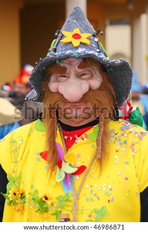 VIAREGGIO, ITALY - FEBRUARY 14: Man in carnival mask with big nose and funny hat, during the famous Carnival of Viareggio February 14, 2010 in Viareggio, Italy