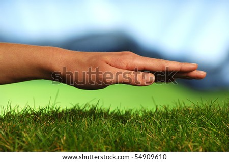Protecting hand on a grass surface