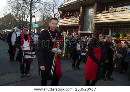 DUISBURG, GERMANY - 15.02.2015 An unidentified woman and man in the annual carnival costumes & masks are on the road. They give sweets to children and adults, play a musical instrument, having fun.