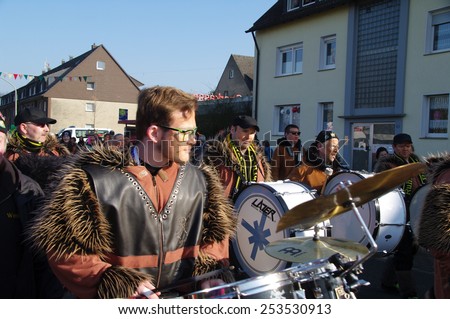 DUISBURG, GERMANY - 15.02.2015 An unidentified woman and man in the annual carnival costumes & masks are on the road.  They give sweets to children and adults, play a musical instrument, having fun.