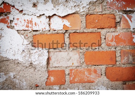 Old brick wall with plaster fallen