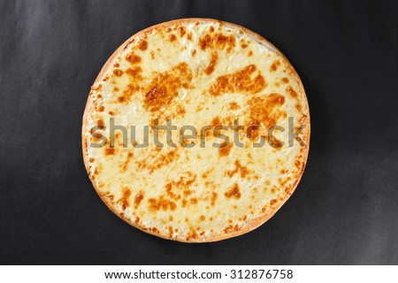 Hot four cheeses delicious rustic homemade american pizza with thick crust on black table