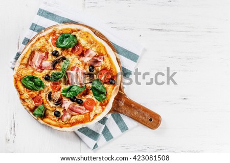 Top view VERY HOT Italian Pizza on white wooden table with mushrooms, basil, tomato, olives and cheese. Look as Prosciutto, Capricciosa, HOMEMADE PIZZA with decoration. Photo with space for text.