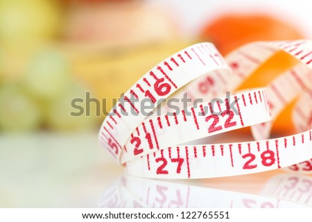Weight watcher - Measuring tape with different fruits at the background (V-Format ID 174374312)