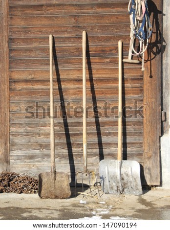 Farm tools in front of a Swiss wooden old barn