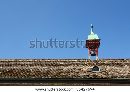 Old Roof with Small Bell Tower against blue sky