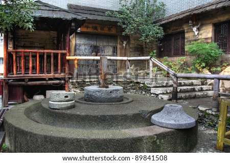 Chinese traditional village with a stone mill at the foreground
