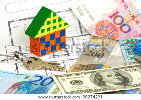 Colorful wooden house and keys on diverse currencies and architecture plan
